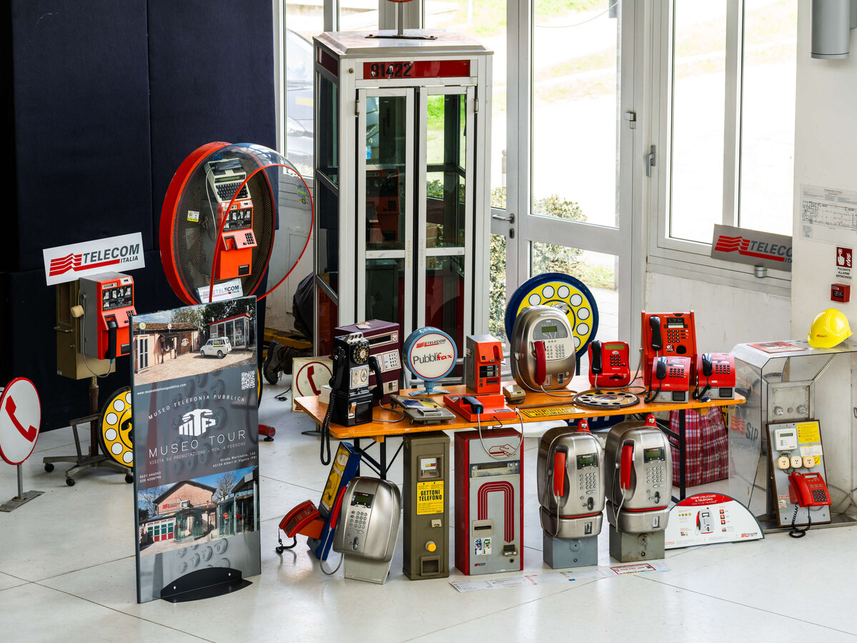 Stand du Museo Telefonia Pubblica au PIM 2026, avec des téléphones publics anciens, une cabine téléphonique et le totem du musée.