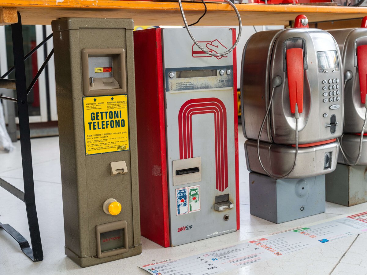 Distributeur de jetons à côté des téléphones publics à carte du Museo Telefonia Pubblica, du jeton à la télécarte.