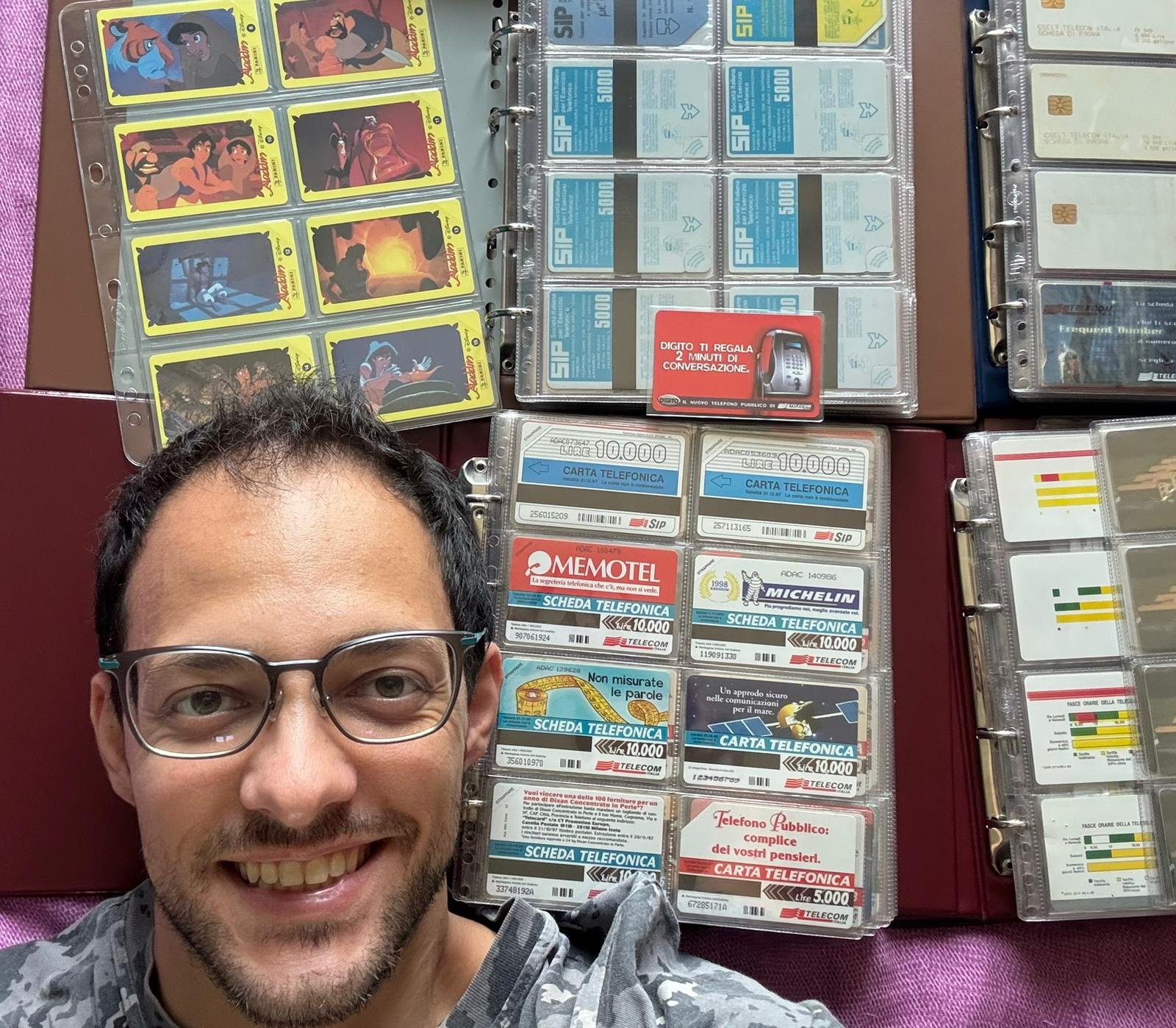 Andrea Franzoni with his collection of Italian phonecards, among binders and albums