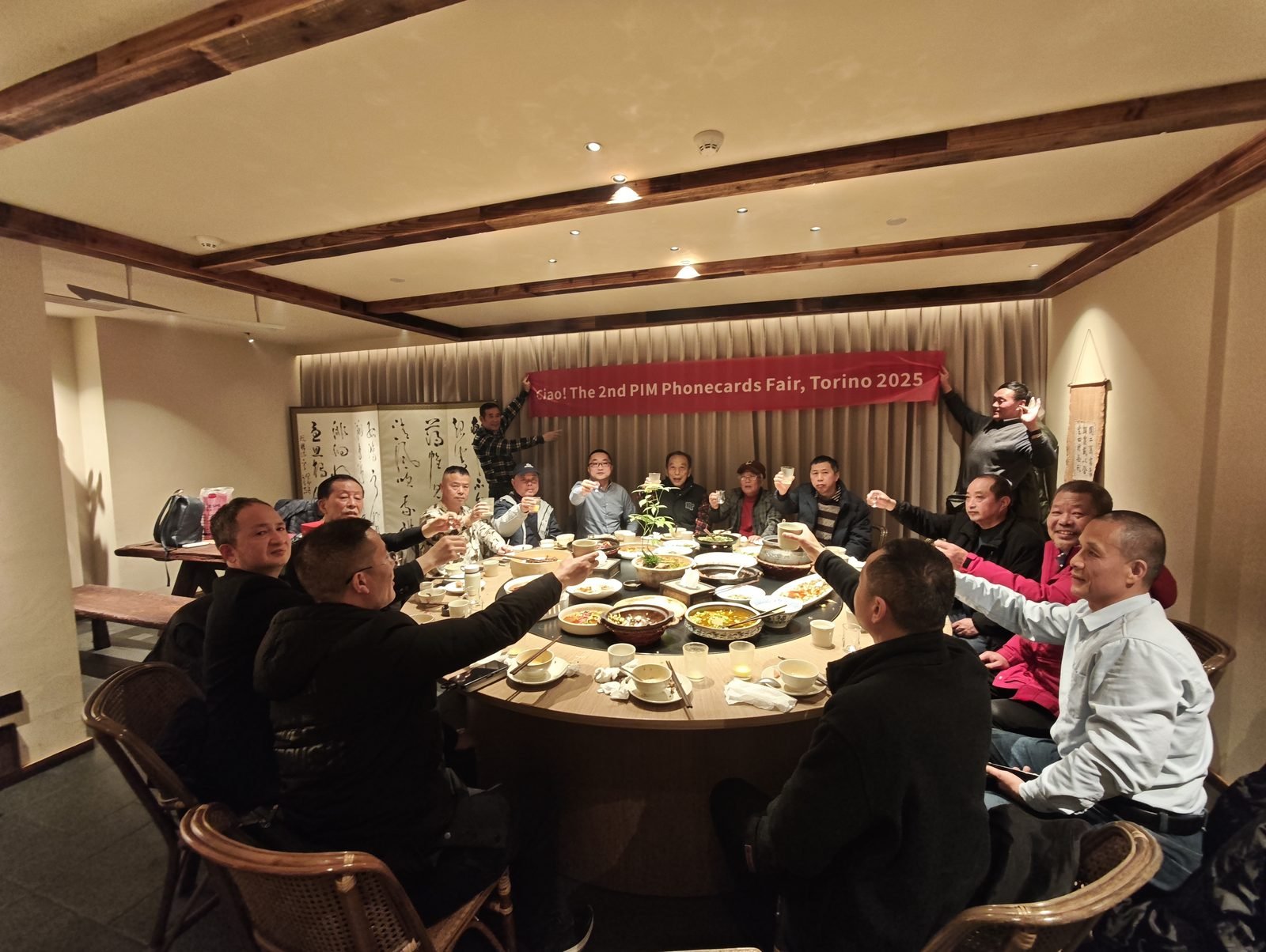 Chinese collectors toasting with a banner celebrating the PIM 2025 in Torino