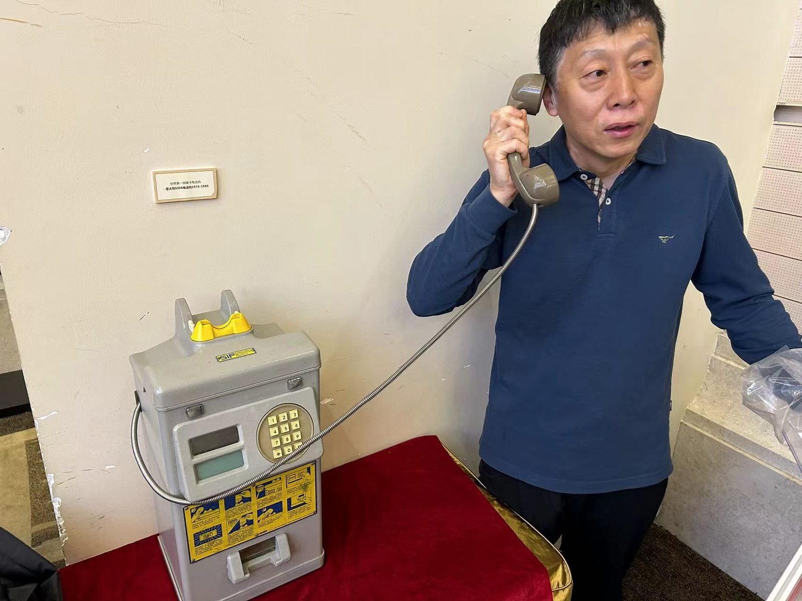 Yang Xiao Dong with the world's first phonecard payphone (SIDA, Italy, 1976-1980), displayed in China
